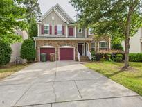 Charming two-story home featuring a stone facade, red shutters, brick steps, and two-car garage at 1728 Callandale Ave, Cary, NC 27518
