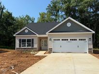 Charming one-story home features a two-car garage and a well-manicured lawn at 1995 Meadowview Dr, Graham, NC 27253