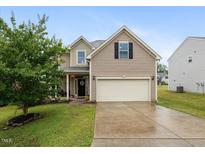 Charming home featuring a two-car garage, well-manicured lawn, and inviting front porch at 215 Outwater Ridge Dr, Garner, NC 27529