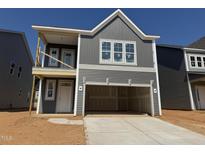New construction two-story home boasts a gray exterior with a two-car garage and modern architectural design at 256 Meadowbark Bnd # 45, Garner, NC 27529