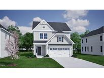 Charming two-story home with a two-car garage, lush green lawn, and traditional architectural details at 264 Meadowbark Bnd # 43, Garner, NC 27529