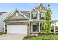 Charming two-story home featuring brick accents, attached two-car garage, and a well-manicured front lawn at 304 Ford Meadows Dr, Garner, NC 27529