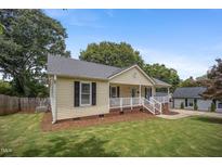 Charming one-story home with a well-manicured lawn and inviting front porch and detached garage at 304 S Smith St, Clayton, NC 27520