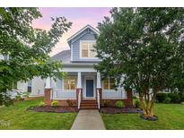 Charming two-story home with a welcoming front porch, manicured lawn, and beautiful landscaping at 307 Millbrook Dr, Pittsboro, NC 27312