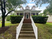 Charming brick home featuring a welcoming front porch and well-maintained landscaping at 3116 Kirby St, Durham, NC 27713