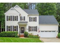 Charming two-story home with manicured lawn, black shutters, and a cozy front porch at 4329 Hawksong Pl, Cary, NC 27518