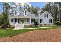 Charming two-story home featuring a welcoming front porch with a bright green door and well-manicured landscaping at 4416 Thistlehill Ct, Raleigh, NC 27616