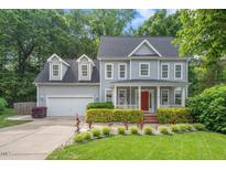 Charming two-story home featuring a manicured lawn, bright red door, and lovely landscaping at 5 Providence Ridge Ln, Durham, NC 27713
