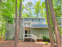 Charming two-story home featuring a covered entryway, set amidst a lush green forest landscape at 516 Ryan Rd, Cary, NC 27511