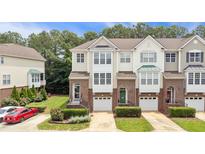Charming townhomes feature brick and siding exteriors, private garages, and beautifully landscaped front yards at 5503 Silver Moon Ln, Raleigh, NC 27606