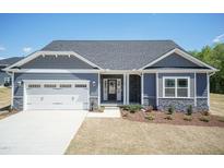 Charming single-story home with a two-car garage, stone accents, and manicured front yard at 56 Braddock Ct, Garner, NC 27529