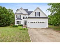 Charming two-story home with a well-manicured lawn and attached two car garage at 5608 Scottish Hills Dr, Holly Springs, NC 27540