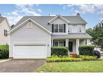 Charming two-story home featuring a well-maintained yard and attached two-car garage at 5637 Yates Garden Ln, Raleigh, NC 27606