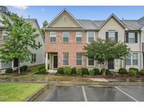 Charming townhome with brick facade, manicured landscaping, and inviting entrance at 68 Holly Berry Ln, Durham, NC 27703