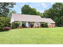 Charming brick ranch home featuring a well-manicured lawn and landscaping at 816 Miller Rd, Hillsborough, NC 27278