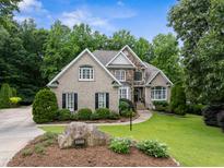 Elegant brick home with stone accents, manicured lawn, and lush landscaping at 8405 Hempton Cross Dr, Wake Forest, NC 27587