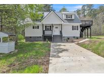 Charming two-story home featuring a gray metal roof and covered porch with black trim at 852 Fred Wilder Rd, Franklinton, NC 27525