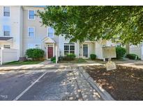 Townhouse exterior featuring neutral siding, well-kept landscaping, and visible community signage at 8621 Neuse Club Ln # 106, Raleigh, NC 27616
