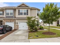 Charming townhome featuring a one car garage, neutral siding, and well manicured front yard at 1102 Latitude Dr, Durham, NC 27713