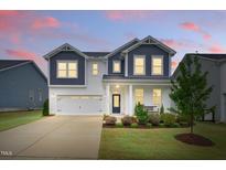 Charming two-story home featuring a well-manicured lawn, beautiful landscaping, and a classic facade at 1112 Prewitt Ranch Dr, Holly Springs, NC 27540