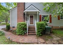 Charming home entrance with brick steps, red shutters, a brick chimney, and lush landscaping at 119 Danforth Dr, Cary, NC 27511