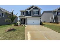 Two-story home with gray siding, a two-car garage, and a well-manicured front lawn at 128 Bruce Dr, Dunn, NC 28334
