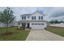 Charming two-story home featuring a manicured lawn, attached two-car garage and classic architectural details at 140 Benson Village Dr # 83, Benson, NC 27504