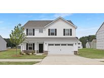 Beautiful two-story home featuring white siding, black shutters, a two-car garage, and a well-maintained front lawn at 140 Benson Village Dr # 83, Benson, NC 27504