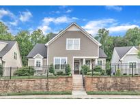 Inviting two-story home featuring a stone retaining wall and a well-maintained front yard at 151 Bridge St, Hillsborough, NC 27278