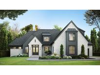 Striking white brick home with black trim, manicured lawn, and professional landscaping creates an inviting curb appeal at 1808 Stream Manor Ct, Wake Forest, NC 27587