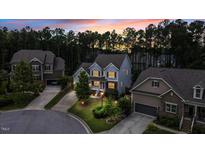 Beautiful two-story home featuring professional landscaping and a welcoming front entrance at sunset at 208 Cecelia Ct, Cary, NC 27519