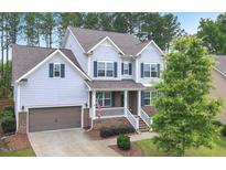 Charming two-story home with blue siding, a covered porch, and a well-manicured front yard at 208 Cecelia Ct, Cary, NC 27519