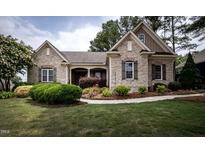 Charming brick home with manicured lawn, shrubbery, and a welcoming walkway at 2109 Taramar Ln, Zebulon, NC 27597