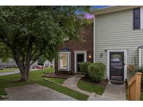 Charming townhome featuring a mix of brick and siding, complemented by lush landscaping and a welcoming entrance at 2201 Alpine Rd, Durham, NC 27707