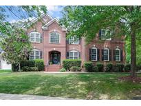 Stately brick home with manicured lawn and mature trees offering classic curb appeal at 225 Norwalk St, Holly Springs, NC 27540