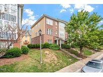 Beautiful multi-story townhouse with brick and yellow siding on a well manicured lawn at 229 Michigan Ave, Cary, NC 27519