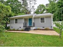 Charming single-story home with gray siding, blue door, updated landscaping, and welcoming curb appeal at 2409 Derby Dr, Raleigh, NC 27610