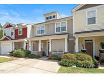 Inviting townhouse showcasing a cozy porch, lush landscaping, and a well-maintained facade under a clear blue sky at 4807 Landover Charge Ln, Raleigh, NC 27616