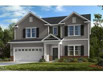 Charming two-story home boasts gray siding, attached garage and well-maintained landscaping at 515 Claftin St, Sanford, NC 27330