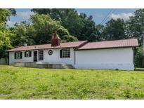 Charming home featuring a red metal roof, white exterior, and lush green lawn at 519 W Raleigh St, Siler City, NC 27344