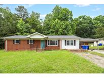 Charming single-story home with a brick facade, bright turquoise front door, and a lovely front yard at 5805 Craig Rd, Durham, NC 27712