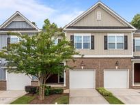Charming townhome with brick accents, attached garages, and mature landscaping at 740 Treviso Ln, Apex, NC 27502