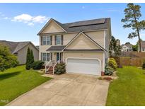 Charming two-story home with a two car garage, solar panels and a well-maintained front yard at 76 Haywood St, Spring Lake, NC 28390