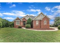 Charming brick home with landscaped yard and inviting front entrance with a blue sky backdrop at 7800 Twin Pines Way, Fuquay Varina, NC 27526