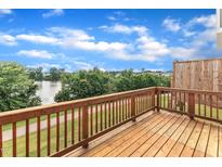 Spacious wooden back deck overlooking a serene lake and lush green walking trail at 816 Lilyquist Way, Wake Forest, NC 27587
