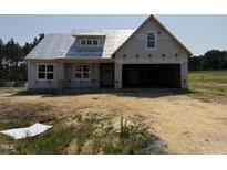 Under construction home featuring a covered porch and spacious two-car garage at 82 Laramie Ln, Selma, NC 27576