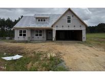 New home construction showing facade, covered porch, and two car garage on a partly cloudy day at 82 Laramie Ln, Selma, NC 27576