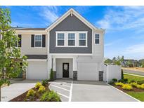 Charming townhouse with a two-car garage, a mix of gray shingles and white panels, and manicured landscaping at 825 Kensley Grove Ln # 19, Fuquay Varina, NC 27526
