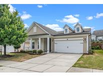 Charming home featuring a two-car garage, beige siding, manicured lawn, and well-maintained landscaping at 826 Downfield Ln, Fuquay Varina, NC 27526