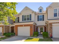 Charming two-story townhome with a brick-accented garage and manicured landscaping at 8404 Saltwood Pl, Raleigh, NC 27617